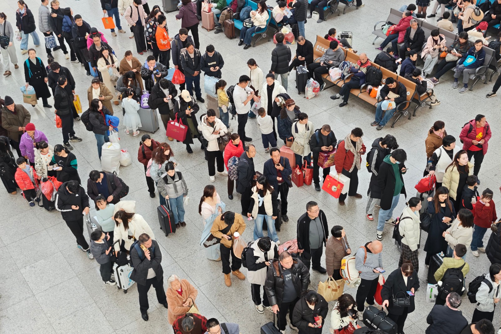 图示：候车厅内旅客或看手机或整理行李 人潮密集（汪亮 摄）.jpg