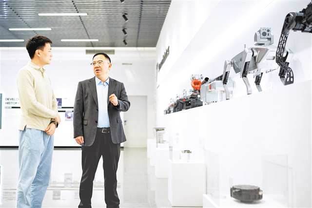 杨文利（右）在重庆七腾机器人有限公司了解相关项目最新进展。记者 李裕锟 摄/视觉重庆