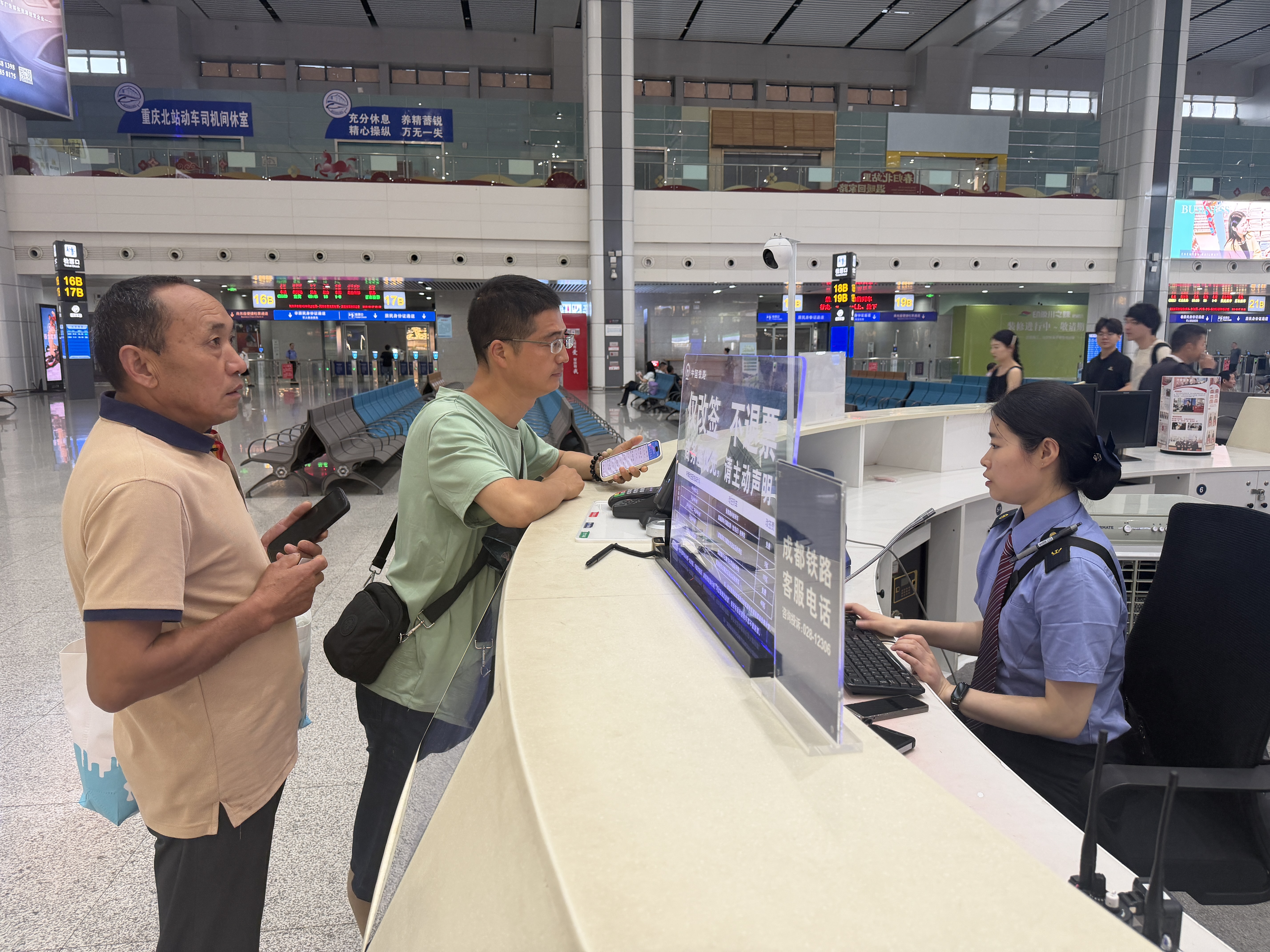 重庆北站马廉服务台工作人员为旅客办理车票改签。蒋远智,摄.jpg