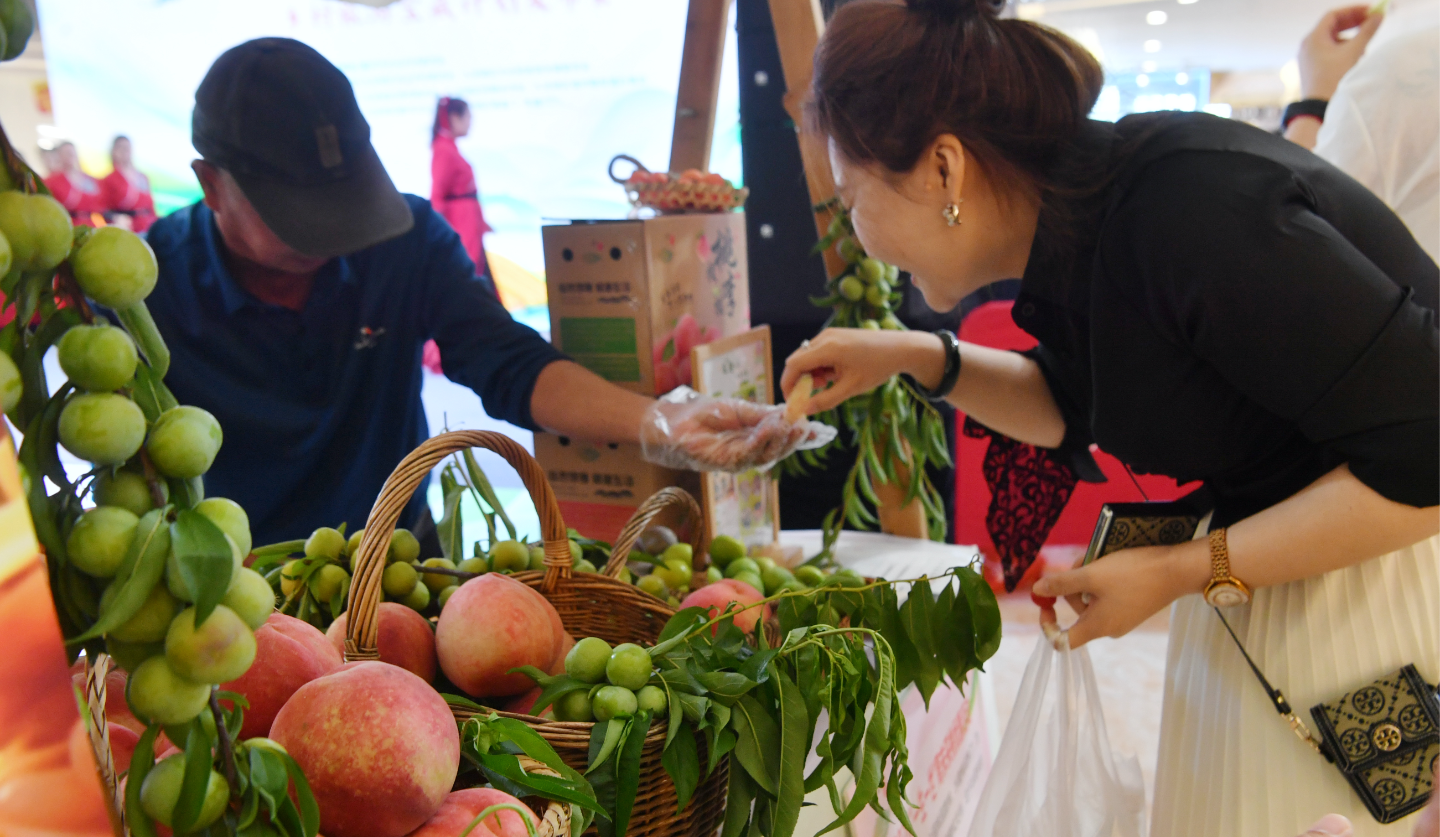 市民品鉴选购特色生鲜水果。记者 周邦静 摄.png